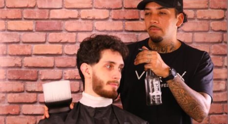 homem fazendo atendimento de barbearia em salão de beleza
