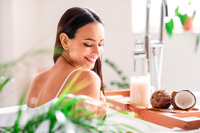 mulher aplicando óleo de coco no cabelo