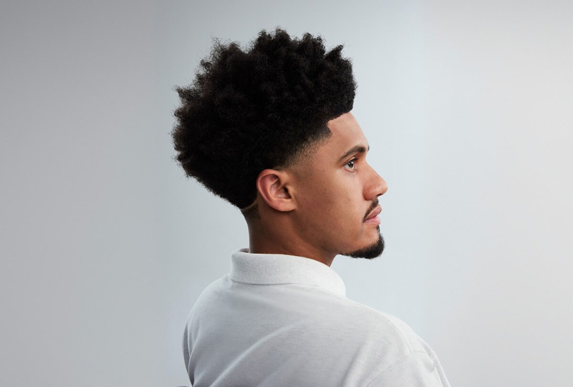 homem negro com cabelo crespo e estilo de corte masculino fade