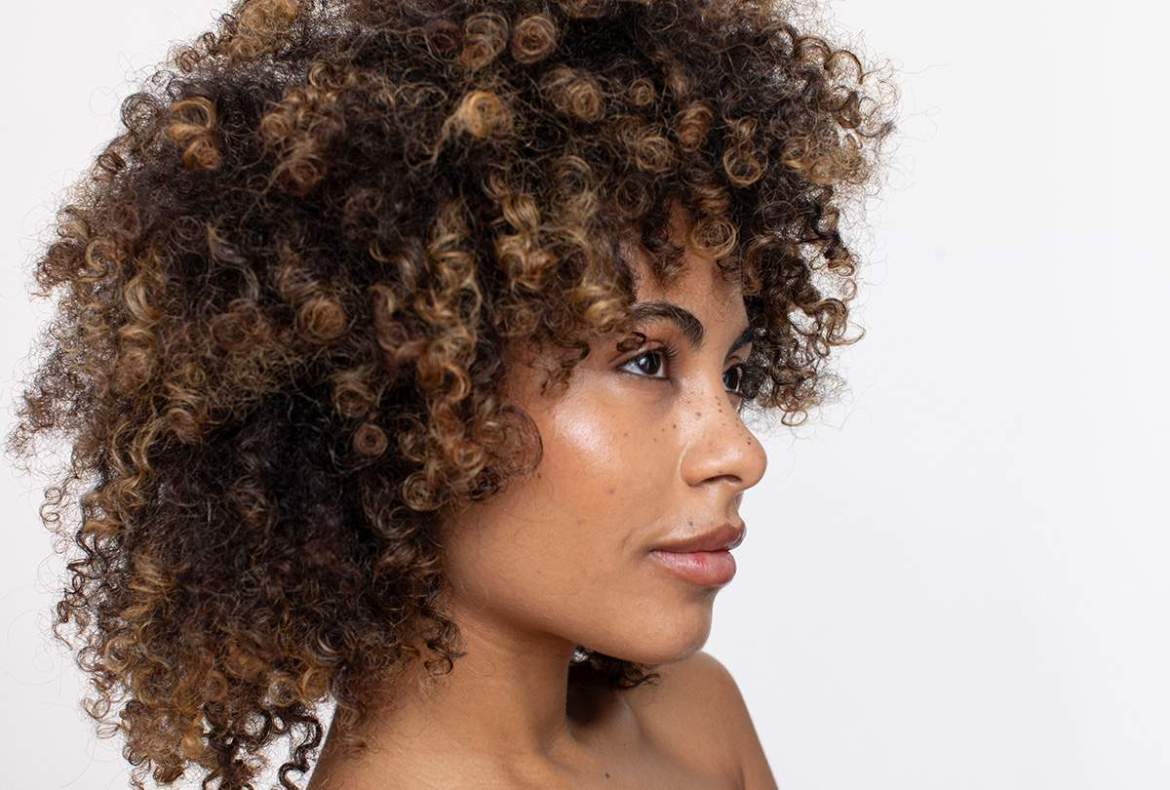 mulher com cabelo crespo bonito, tratado com óleo para cabelo crespo