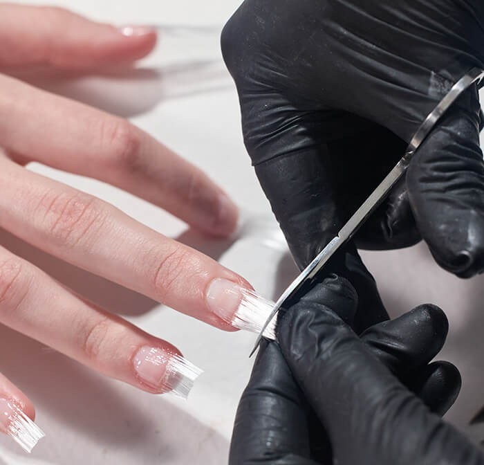 nail designer ou manicure fazendo alongamento de unhas francesinha utilizando fibra de vidro em tufos